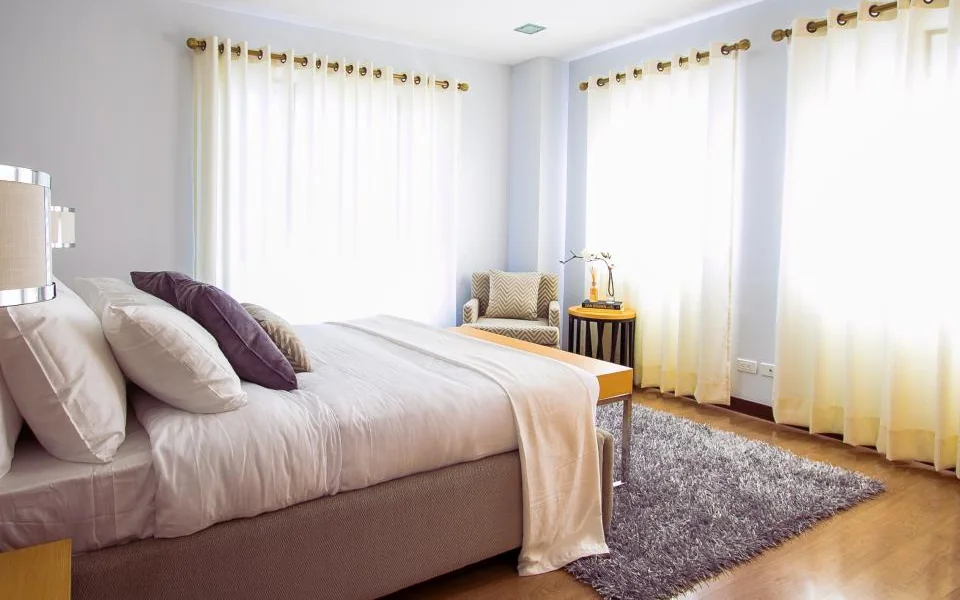 A tidy bedroom with soft morning light